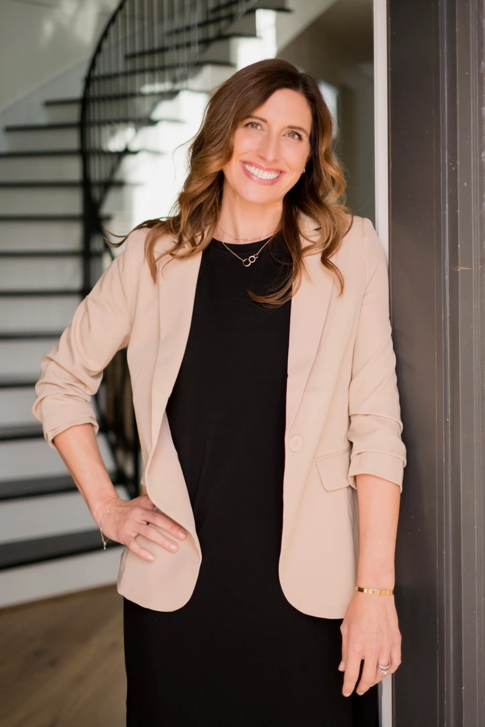 Carrie Groce smiling in a neutral blazer