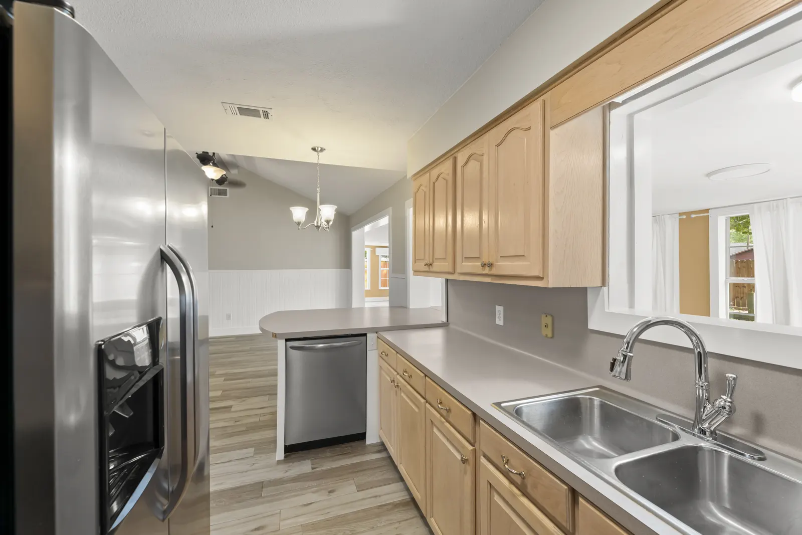 Kitchen with stainless refrigerator and dishwasher